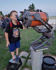 Enfant observant au télescope sur le Pré aux Étoiles